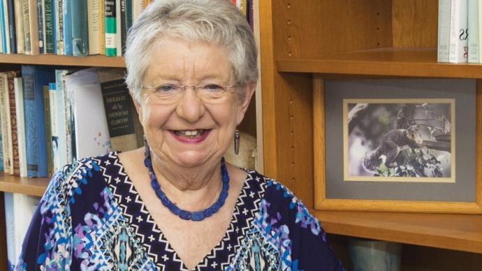 Close up headshot of Coleen Grissom in front of her bookcase.