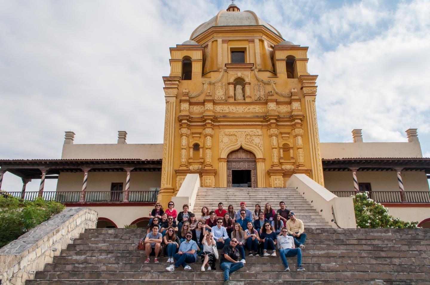 Student group poses in front of building.