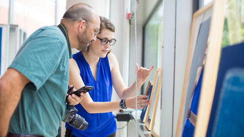 Sasha Faust explaining art work to a man