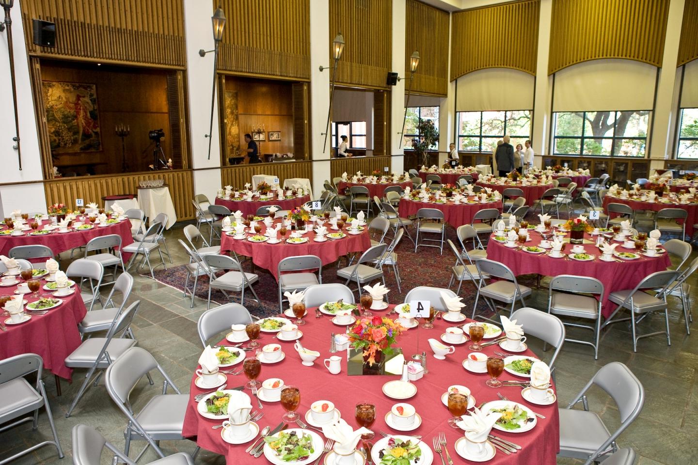 Tables set up for lunch, with dishes, utensils, and food on them