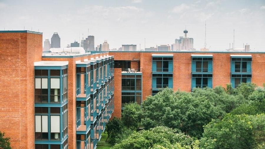 Exterior view of Prassel Hall with San Antonio skyline in the background